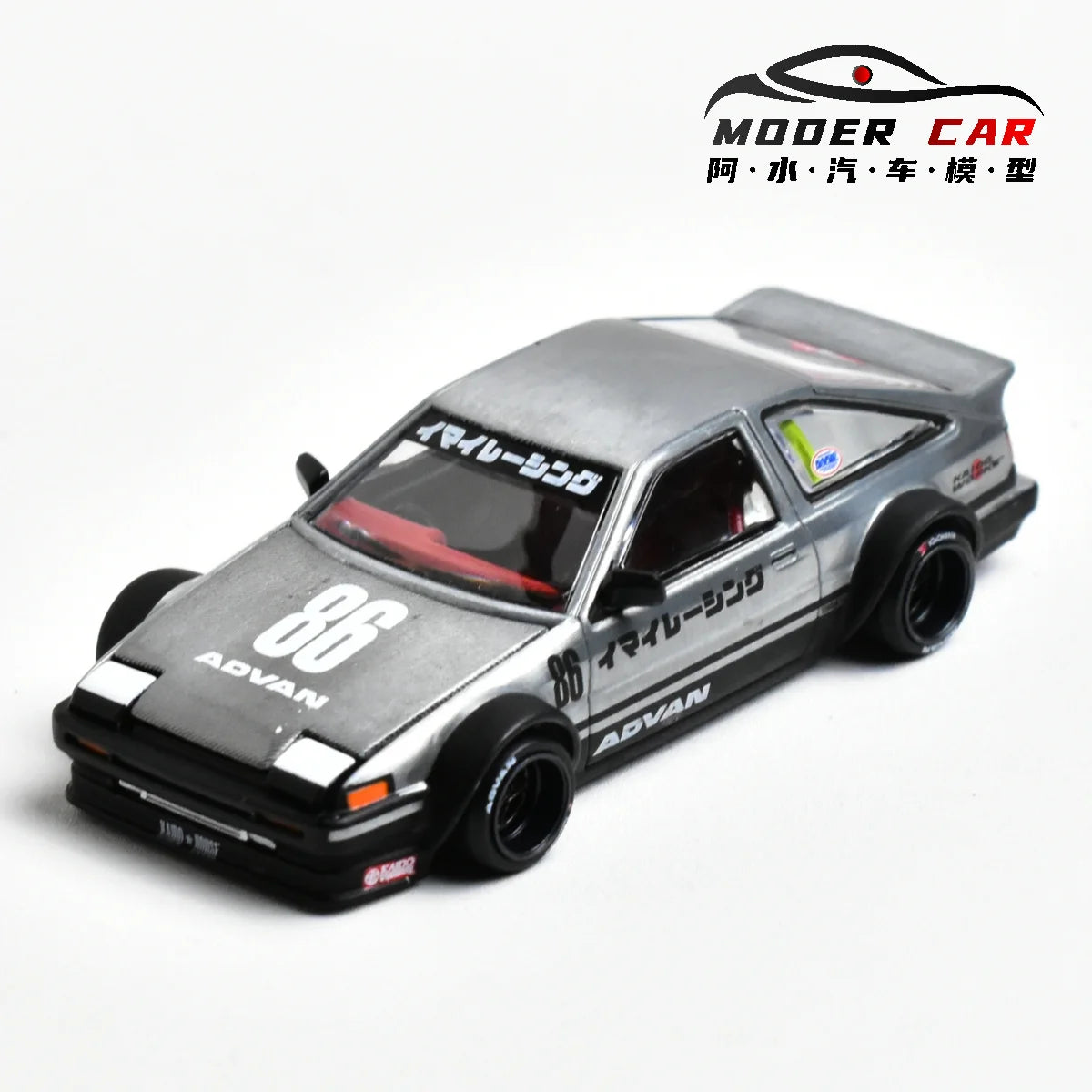 A silver diecast model of a Toyota AE86 sports car with racing decals and aftermarket wheels.