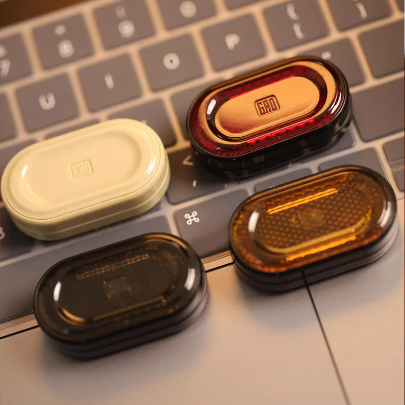 A collection of metal mechanical fidget sliders in various colors and finishes resting on a laptop keyboard.
