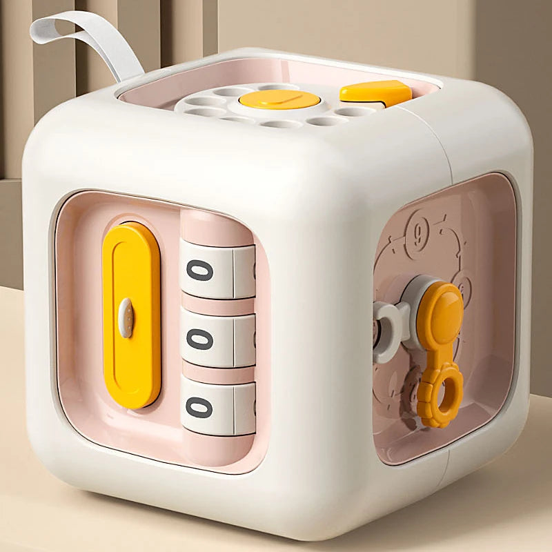 A white and pink Montessori busy cube for toddlers with a lid and various puzzle pieces inside.