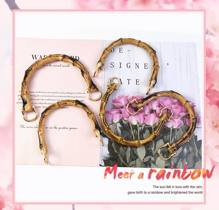 Golden bamboo-style bag handles displayed against a pink floral background.
