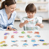 A collection of wooden magnetic fishing game pieces for children, including fish and other shapes.
