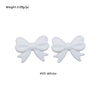A pair of white silicone bow tie beads for jewelry making and craft projects.