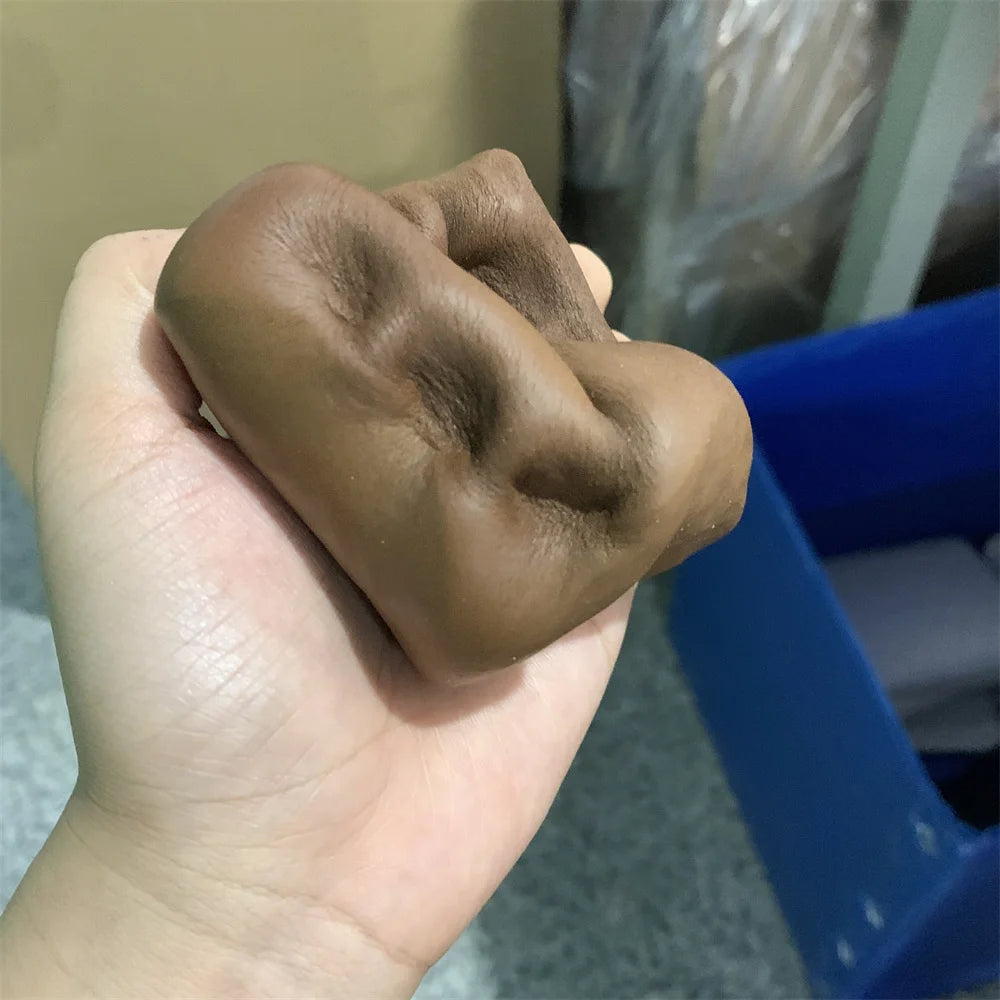 Une main tient un pain décoratif en pâte douce et marron sur un fond bleu.