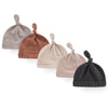 A collection of five knitted baby hats in neutral and earthy tones including gray, brown, beige, and black