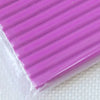 A close-up view of a purple polymer clay kit, showing the soft modeling clay molded in parallel ridges.