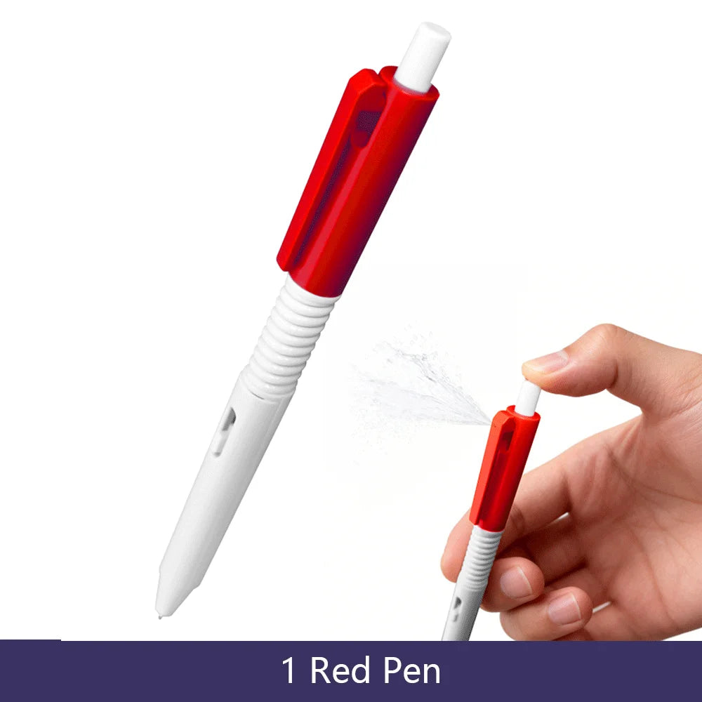 A hand is holding a red pen and spraying water from the tip onto a white surface.