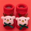 Pair of red baby anti-slip cotton socks with festive Christmas designs featuring reindeer heads