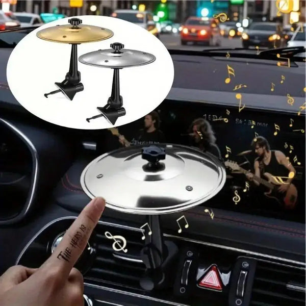 A silver crash cymbal instrument is shown resting on a car interior air vent.
