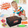 A child is playing a balloon popping game with orange and pink balloons and a black box.