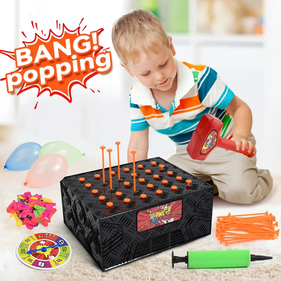 A child is playing a balloon popping game with orange and pink balloons and a black box.