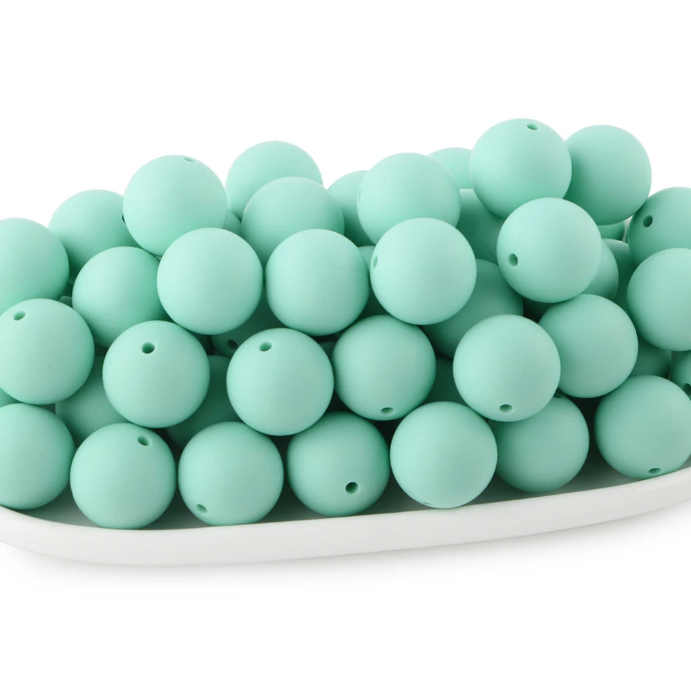 A pile of light mint green round silicone beads for jewelry making and DIY crafts.