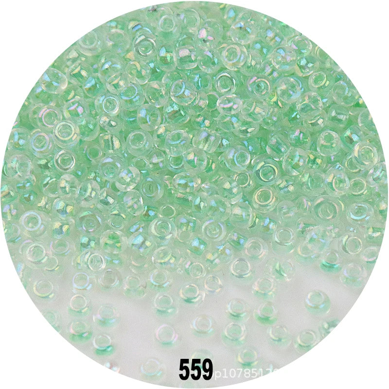 A circular image showing numerous small, round, light green glass seed beads.