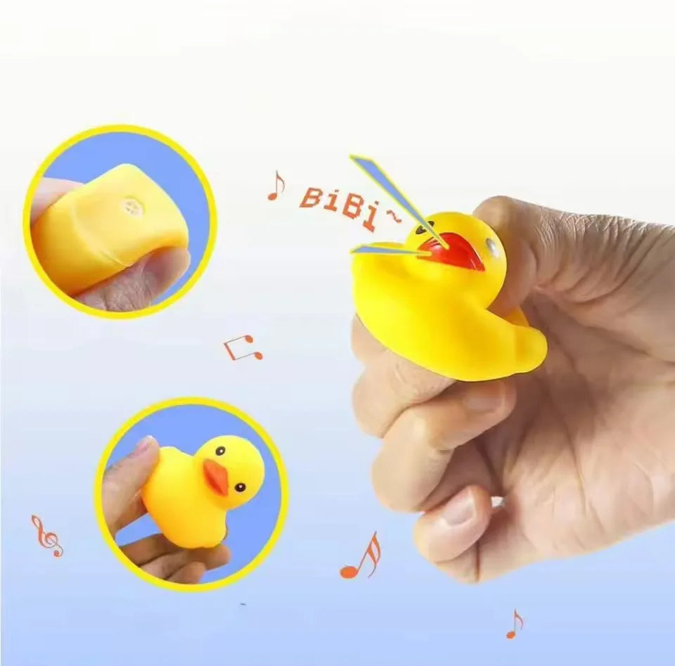 A hand holds a yellow silicone duck bath toy with a straw, demonstrating the squeaky floating duck.