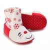 A pair of red and white baby winter boots featuring a festive snowflake pattern on the cuff.