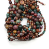 A collection of natural stone round beads in various shades including rose quartz, amethyst, and red silk jade.