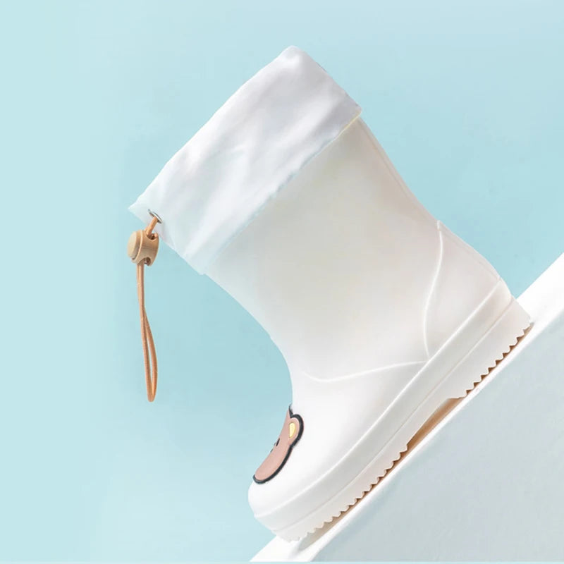 A white kids' waterproof bear rain boot with a slip-on closure shown against a light blue background.
