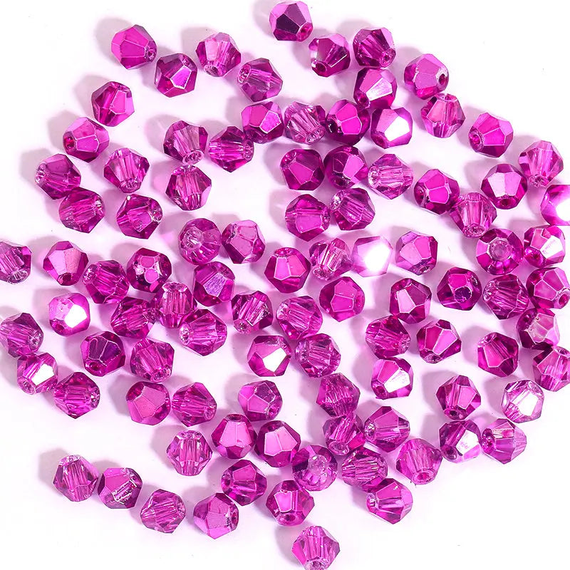 A collection of small, faceted pink and magenta crystal glass beads for jewelry making