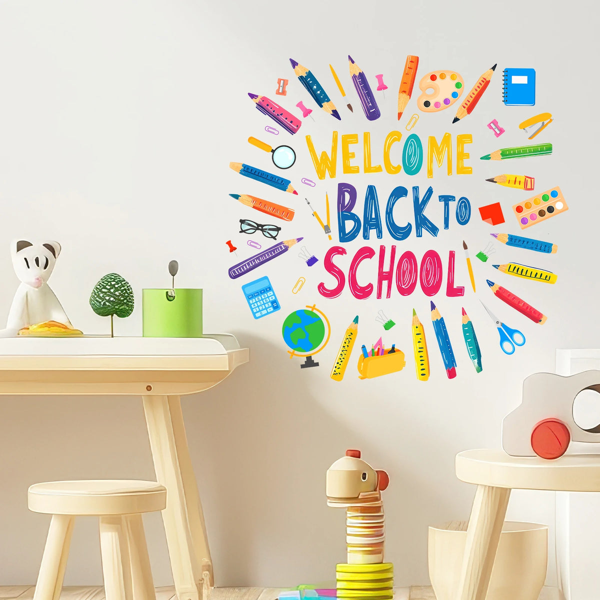 A colorful wall sticker set featuring various crayons, pencils, and markers spelling out Welcome Back to School on a light gr