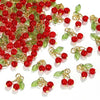 A collection of red cherry glass charms with gold-toned wire stems and green leaves for jewelry making.