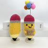Two handwoven crochet pencil ornaments featuring yellow and pink yarn with colorful pom-poms on top
