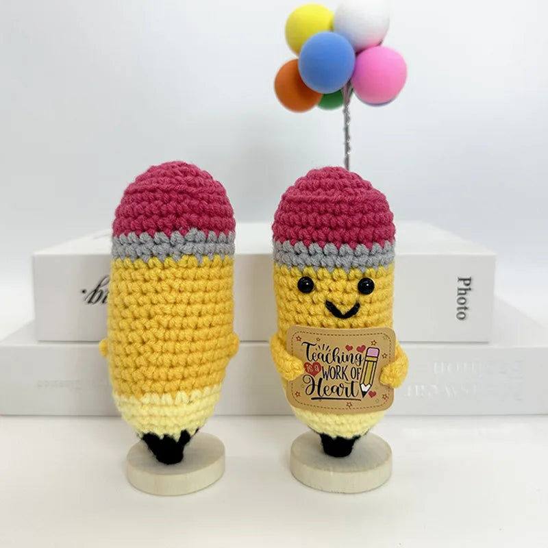Two handwoven crochet pencil ornaments featuring yellow and pink yarn with colorful pom-poms on top