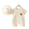 A cream-colored cotton muslin baby romper and hat set for summer