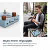 A man is using a portable multi-effects processor and amp modeler on a wooden surface.