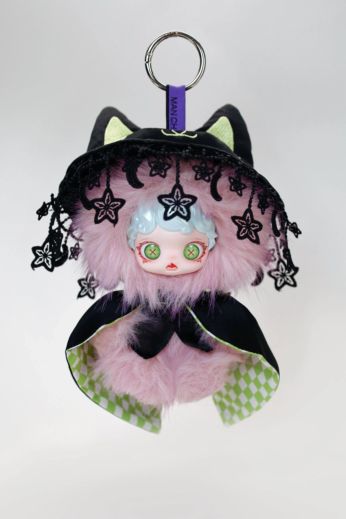 A black and pink plush doll with cat ears and a frilly hood, featuring light blue skin and green eyes.