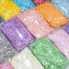 A variety of multicolored raffia paper shreds in yellow, blue, pink, orange, purple, green, and white are displayed for craft