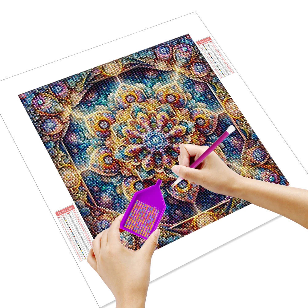 Hands painting a colorful mandala abstract canvas art piece with a fine brush and seed beads.