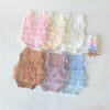 A collection of pastel lace baby rompers in pink, cream, beige, purple, and blue, laid out on a white surface.
