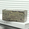 A miniature industrial iron storage box featuring a camouflage pattern resting on a white book.
