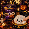 A glowing Halloween mystery box featuring pumpkins and spooky elements, with a hand holding a translucent squishy toy.