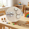 A wooden Montessori busy board for toddlers featuring gears, switches, and sensory elements on a light wood background.