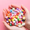 Hands holding a pile of colorful origami star strips for DIY crafting