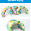 A colorful U-shaped inflatable swim ring with a leafy tropical pattern is shown in various shades of green, pink, and yellow.