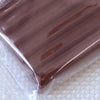 A close-up view of a purple polymer clay kit in soft modeling clay inside a clear plastic bag.