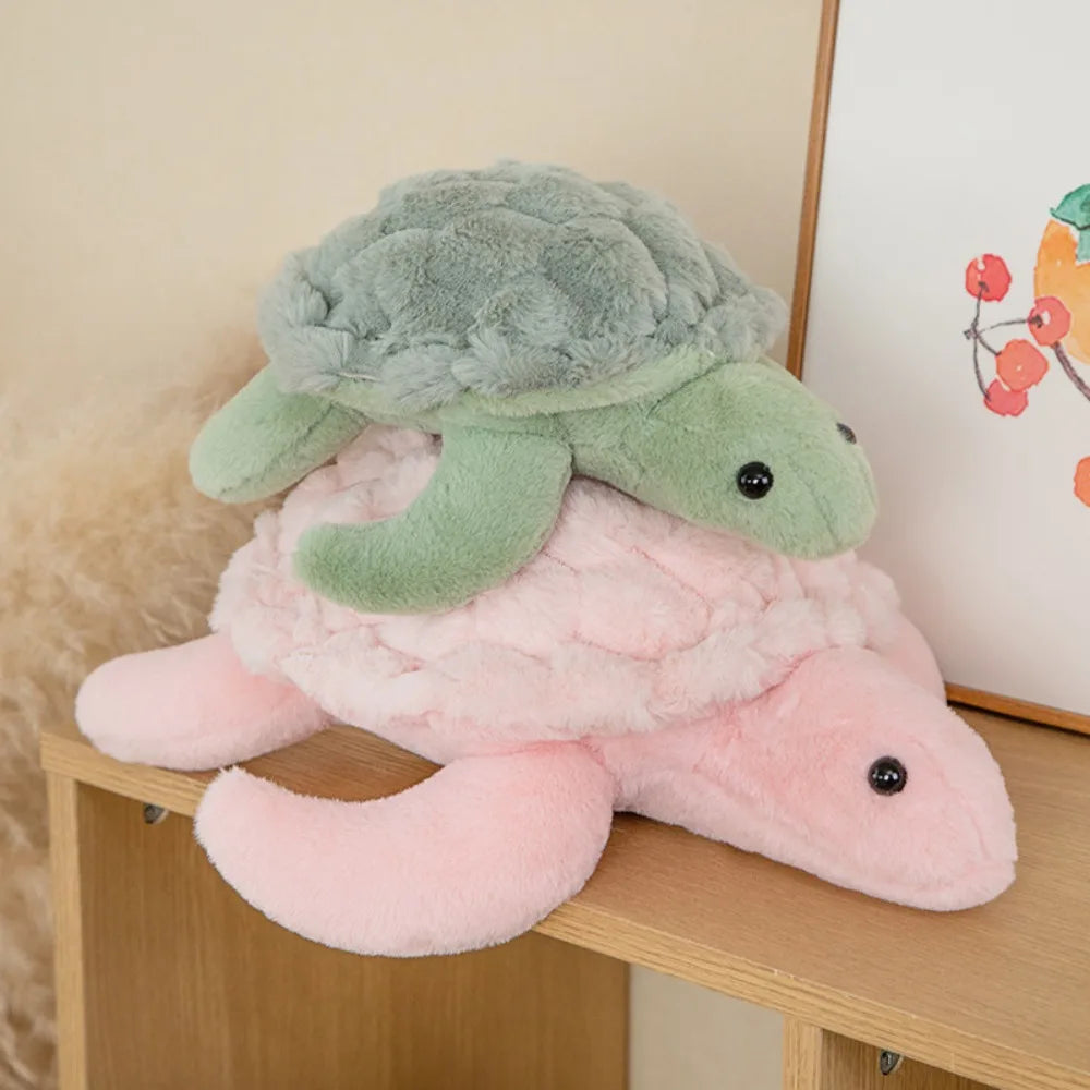 A soft, pink and green sea turtle plush toy resting on a wooden surface.