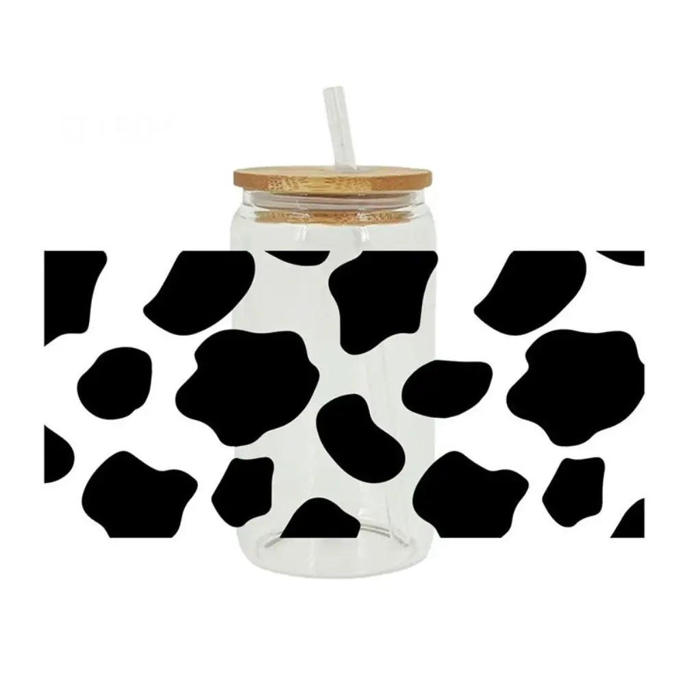 A clear glass cup with a lid and a straw, featuring leopard print UV DTF cup wraps.