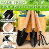 A set of three black gardening tools with wooden handles displayed next to a potted plant.