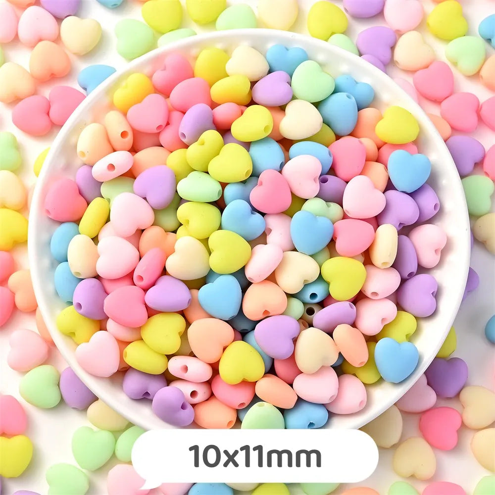 A bowl filled with pastel bear-shaped acrylic craft beads in various shades of pink, yellow, blue, and purple.