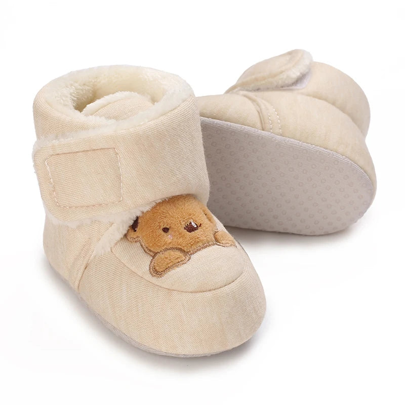 A pair of beige baby winter cartoon boots with soft faux fur trim and a non-slip sole.