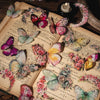 A set of decorative stickers featuring butterflies and flowers on aged paper.