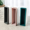 A set of silicone rectangle soap molds in various colors, including gray, pink, and teal, displayed next to a wooden box.