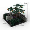 A miniature haunted house diorama built from building blocks featuring dark green foliage, stone structures, and spooky detai