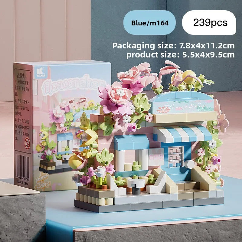 A boxed set of blue and pink micro building blocks depicting a storefront with flowers and a small display.