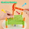 A child's hands are interacting with an orange and green toy featuring various colored hammer nails for fine motor training.
