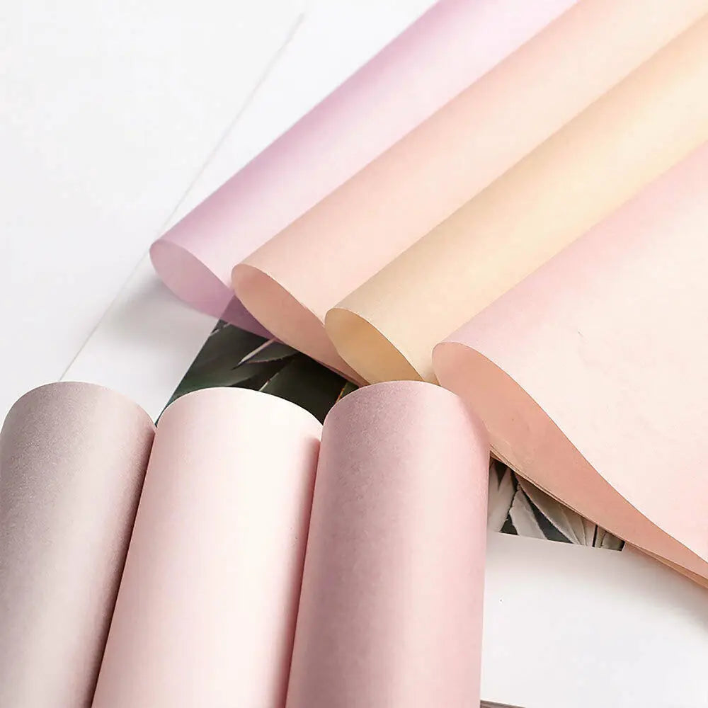 A stack of pink and beige translucent tissue paper sheets for gift wrapping and flower bouquets.