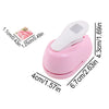 Pink lever action embosser tool with a white embossing plate and measurement markings.
