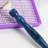 A blue diamond painting pen with an interchangeable tip rests in a purple box lined with white beads.